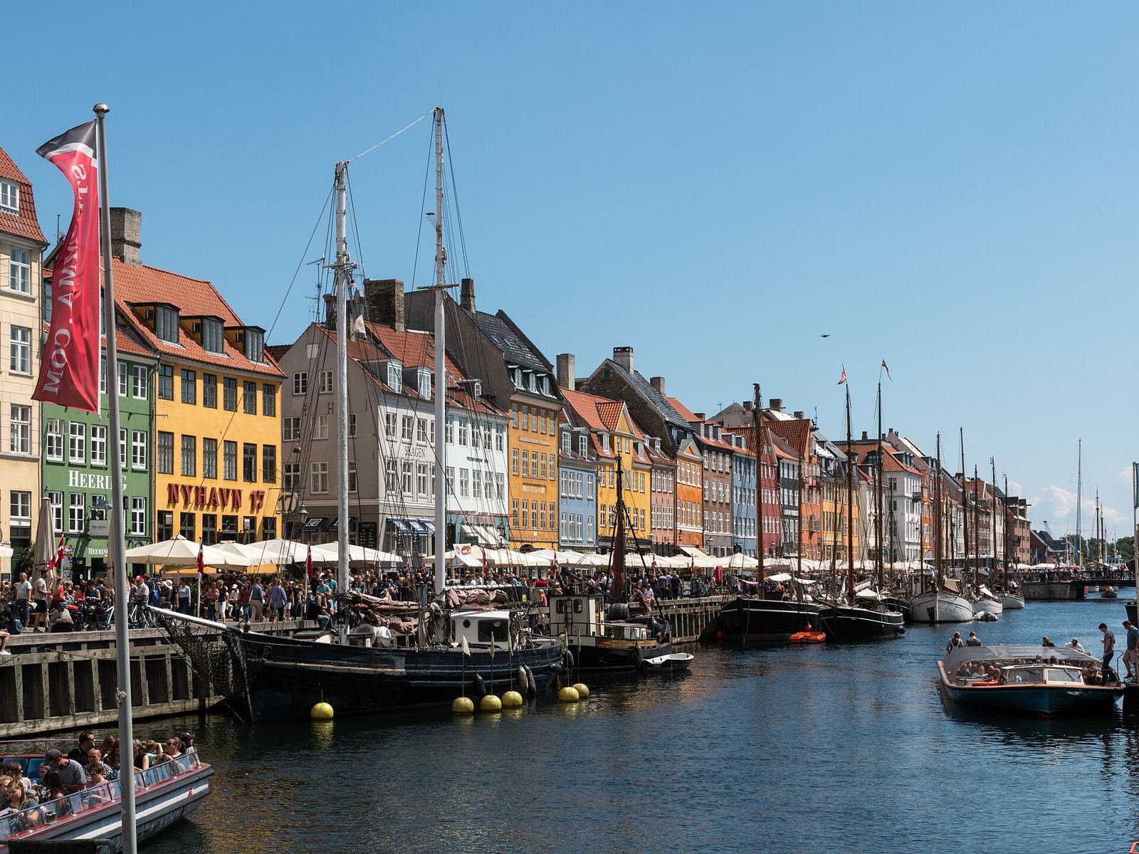 Colourful townhouses and boats along Nyhavn canal in Copenhagen, Denmark